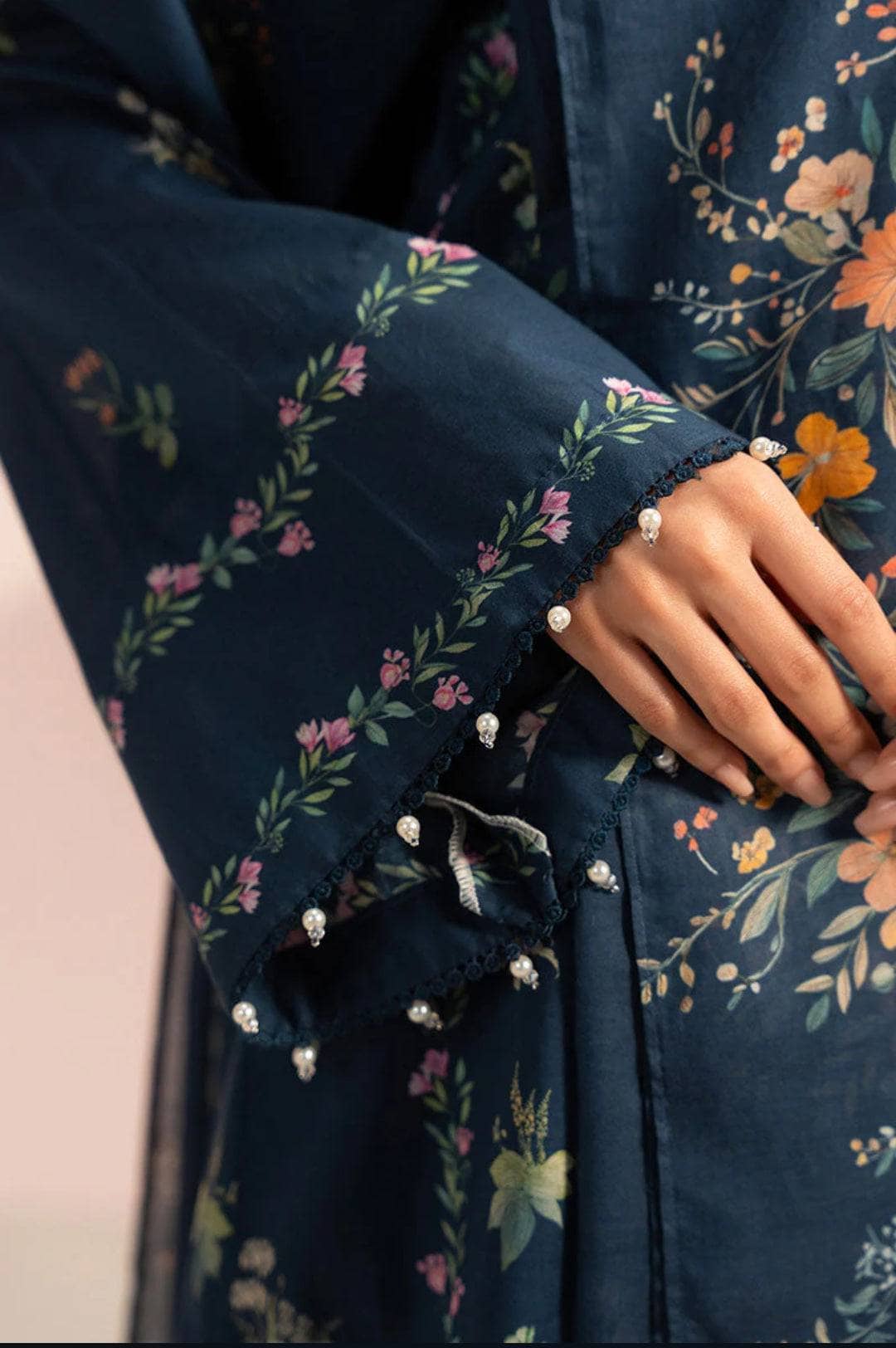 Navy blue floral dress with a close-up of a hand wearing a ring.