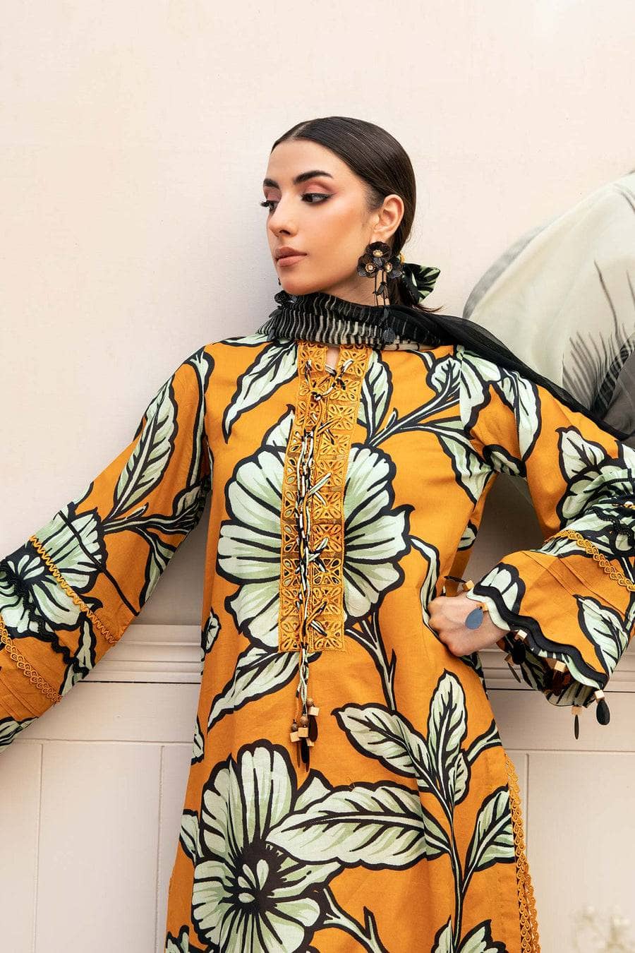 Woman wearing a floral dress with long sleeves against a neutral background
