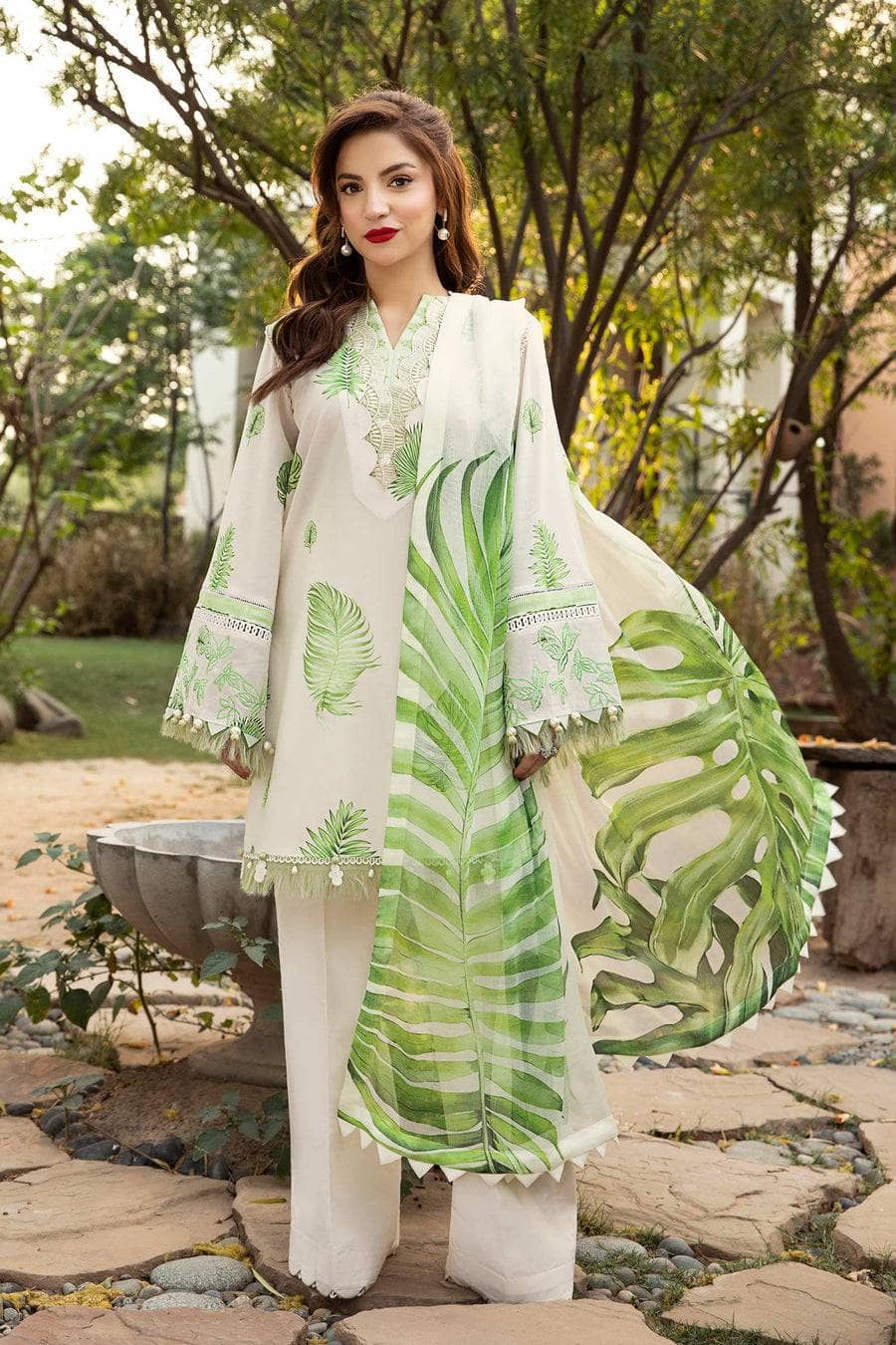 Woman wearing a green and white patterned outfit outdoors.