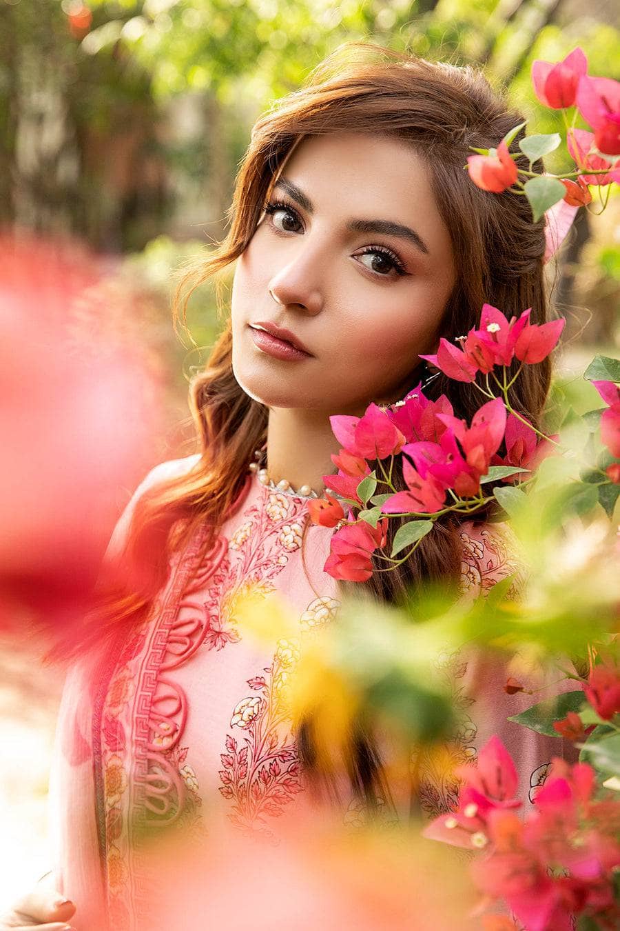 Woman with flowers in her hair and pink floral background