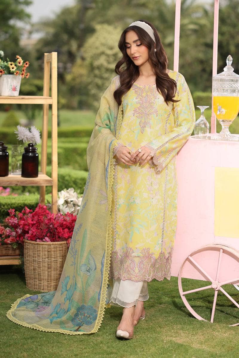 Woman in a yellow and white traditional outfit standing outdoors with floral decorations and a pink cart.