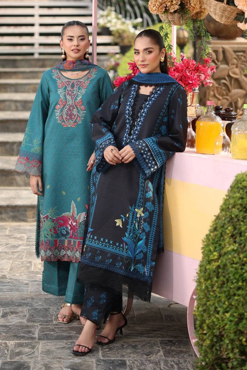 Two women in traditional embroidered outfits standing outdoors with a decorated table in the background.