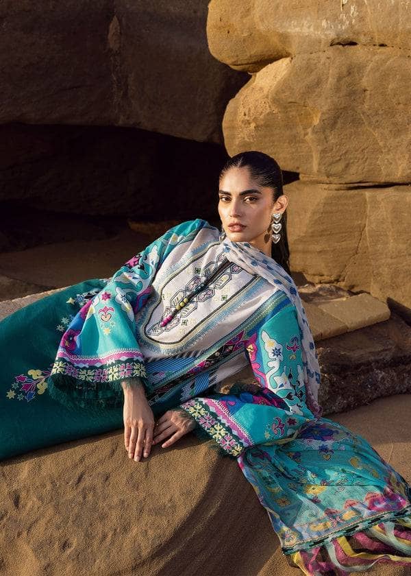 Woman in a colorful traditional outfit sitting against a stone wall.