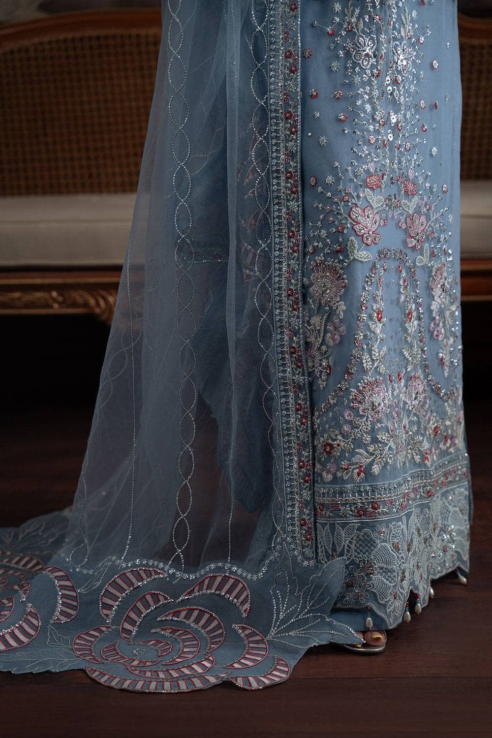 Blue embroidered fabric with intricate patterns on a wooden surface