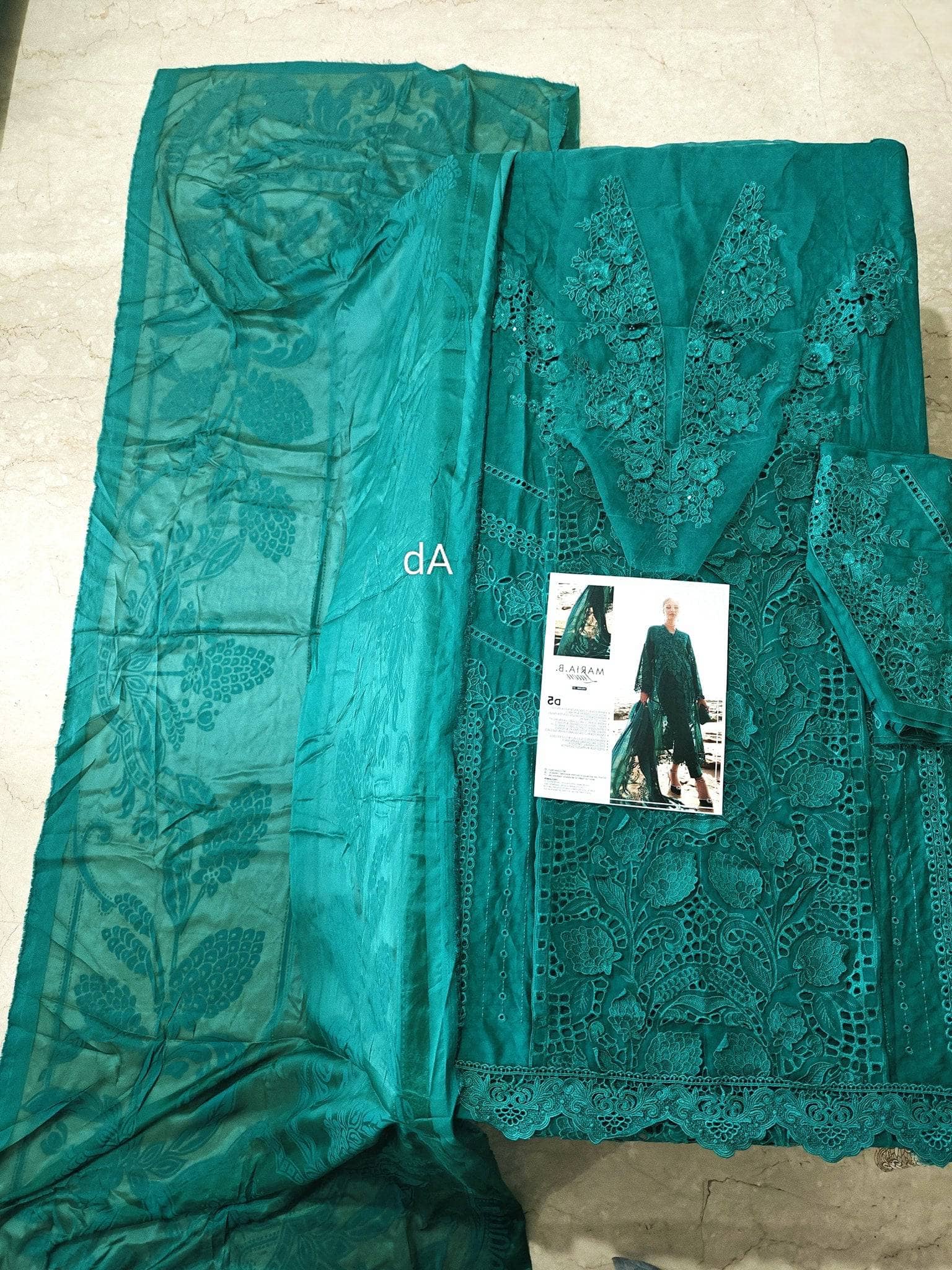 Teal embroidered fabric with a small product image on a neutral background