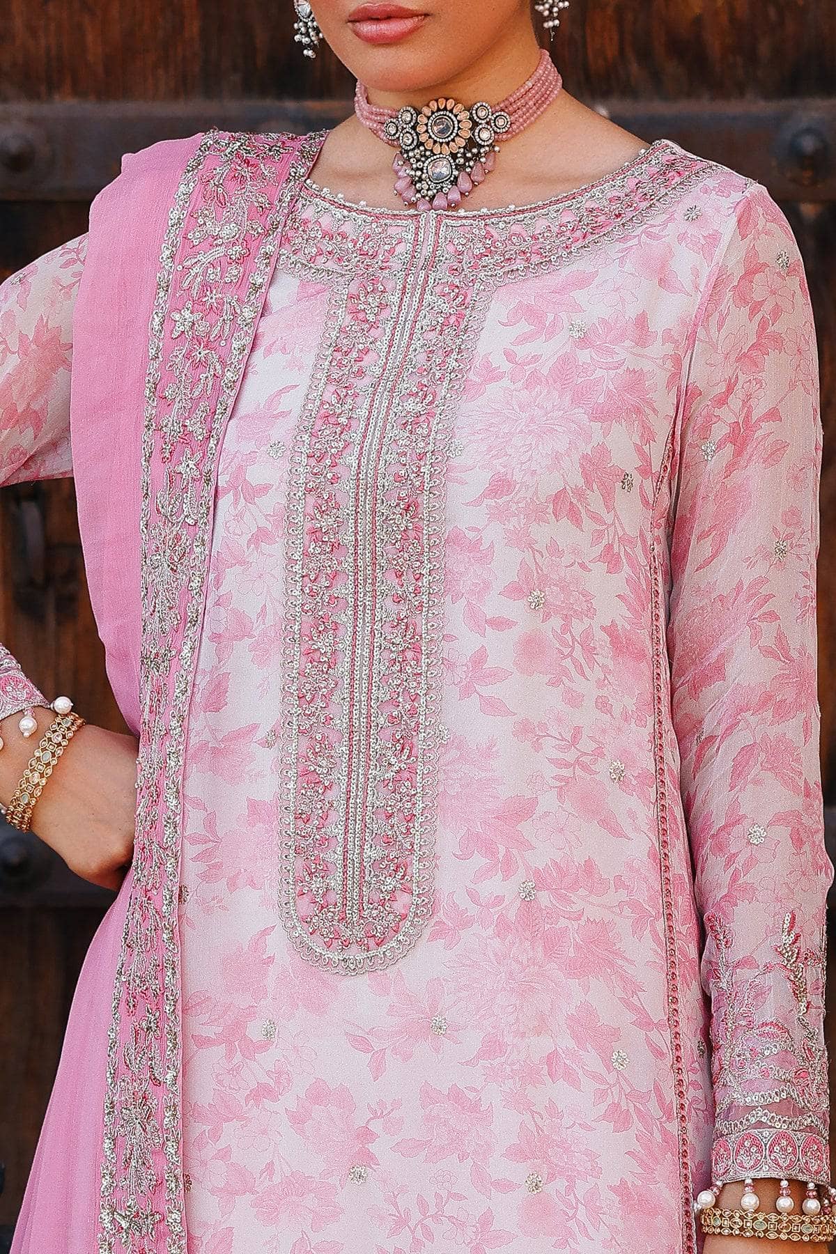 Close-up of a pink embroidered traditional outfit with intricate detailing.