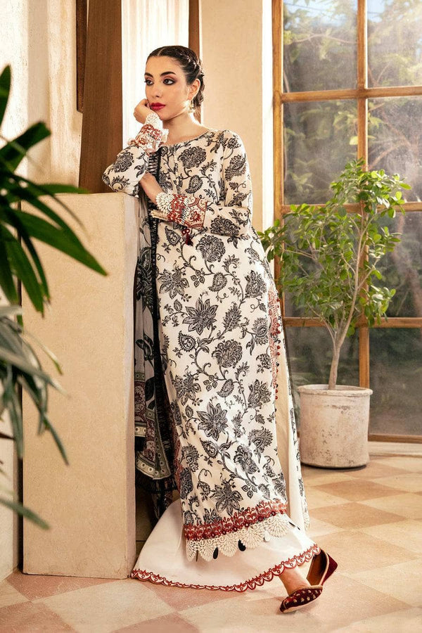 Woman in a floral dress standing indoors with plants and a window in the background