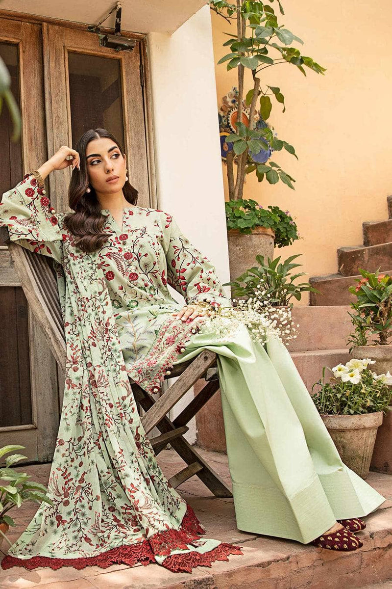 Woman in a floral dress sitting on a wooden chair outdoors with plants around.