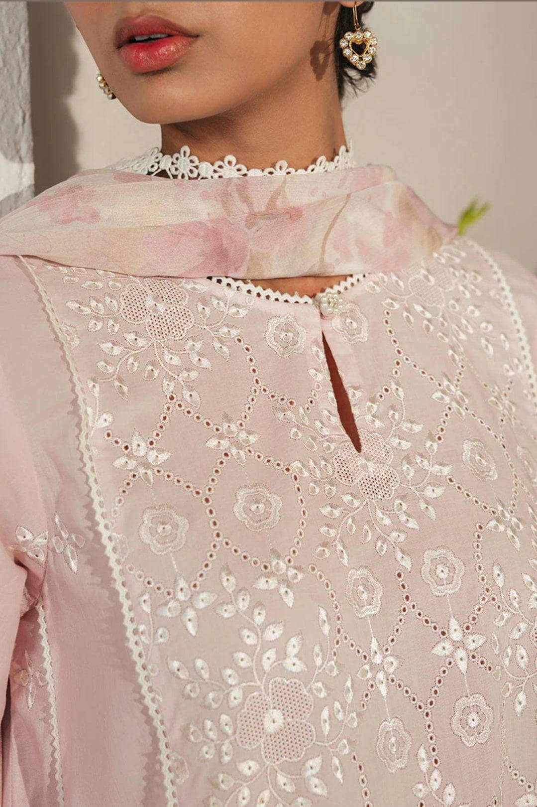 Close-up of a light pink embroidered garment with floral patterns.