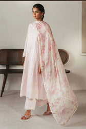 Woman wearing a light pink floral dupatta over a white outfit in a minimalistic setting.