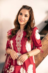 Woman wearing a red and white patterned dress standing indoors.