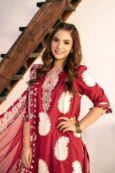Woman wearing a red and white embroidered dress with a wooden staircase in the background