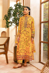 Woman in a yellow embroidered outfit standing indoors with a plant and chair in the background