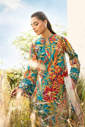 Woman in a colorful floral dress standing in a field with a clear sky.