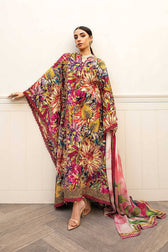 Woman wearing a colorful floral dress against a white wall.