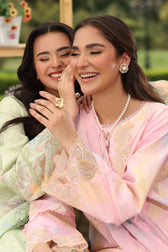 Two women in traditional attire sitting together outdoors.