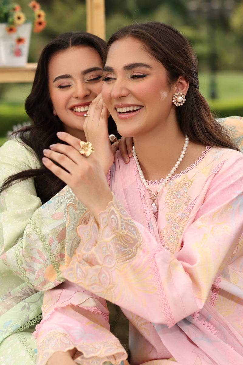 Two women in traditional attire sitting together outdoors.