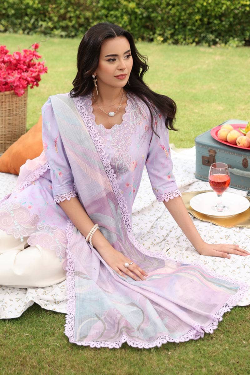 Woman in a pastel-colored traditional outfit sitting outdoors with a picnic setup.