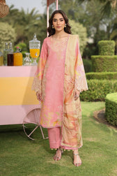 Woman in a pink and gold traditional outfit standing outdoors with a blurred background